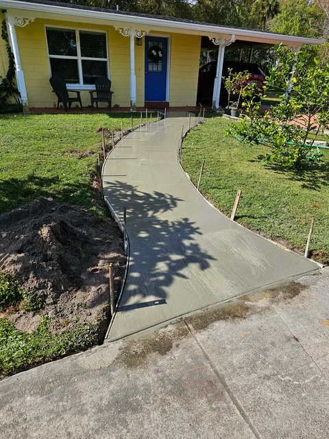 Curved concrete walkway leading to a home